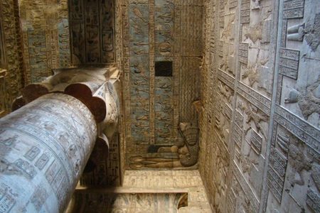 Hieroglyph-covered column and painted blue ceiling with a reclining figure relief inside an Egyptian temple