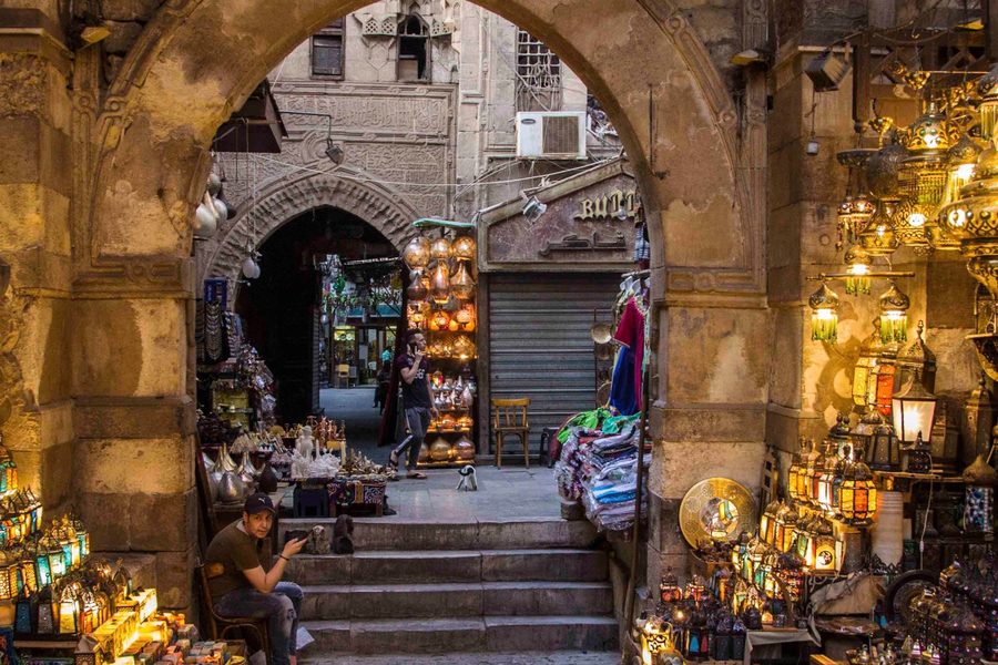 Lantern and brass shops under a stone archway in the Khan el-Khalili bazaar, Cairo