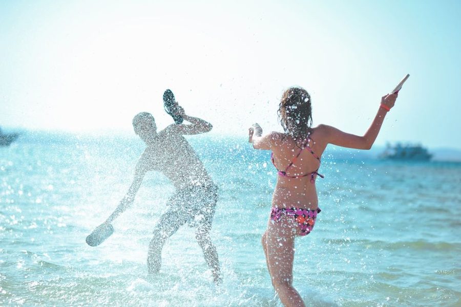 Visitors wading in clear turquoise water along the sandy shoreline of Orange Bay near Hurghada