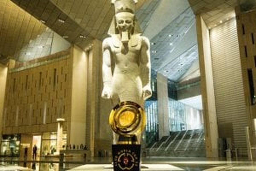 Colossal pharaoh statue standing in the vast main hall of the Grand Egyptian Museum