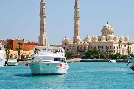 White and turquoise yacht in the marina with El Mina Mosque and its two minarets behind, Hurghada